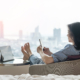 Work-Life balance, life quality, work and travel concept with business woman relaxing sitting in rest, take it easy in modern city hotel guest room or luxury home living room with notebook and smartphone